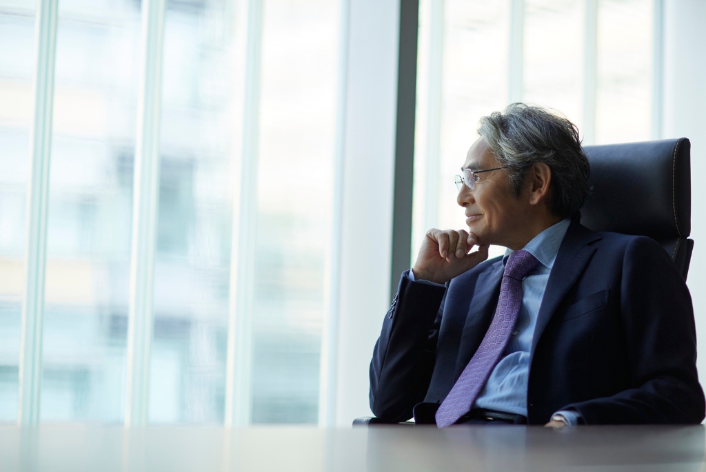 Man sitting at a desk, looking out the window on his executive search