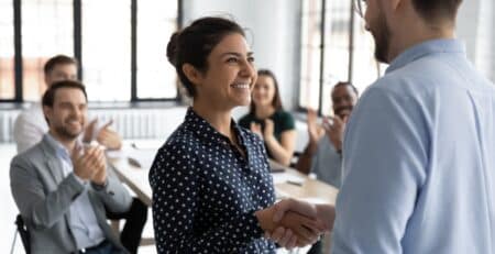 Woman shaking mans hand after executive hiring gave her an internal promotion