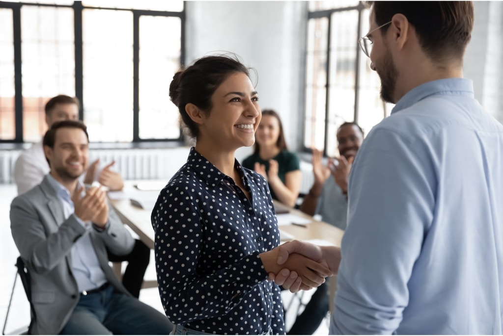 Woman shaking mans hand after executive hiring gave her an internal promotion