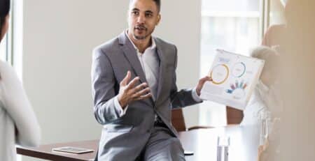 Technical sales person presenting paper presentation to business woman