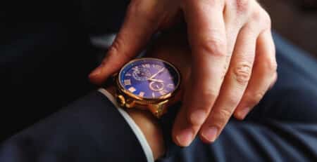 Executive turning watch face on wrist to see timeline for executive hiring