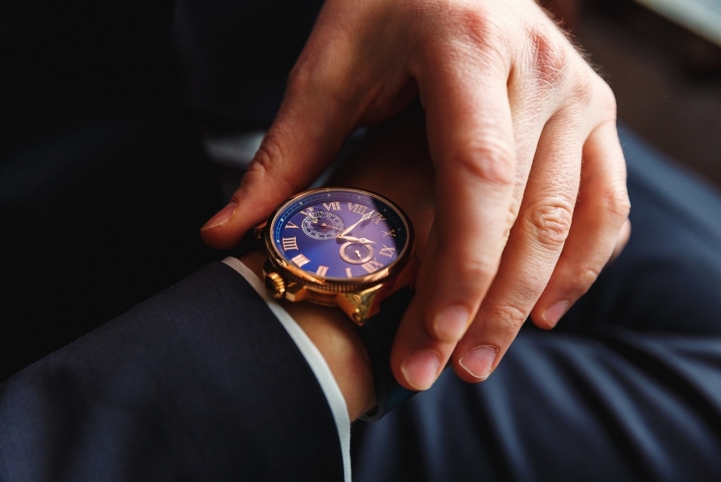Executive turning watch face on wrist to see timeline for executive hiring