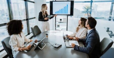Executive in the pharma industry giving presentation to group of employees in a conference room