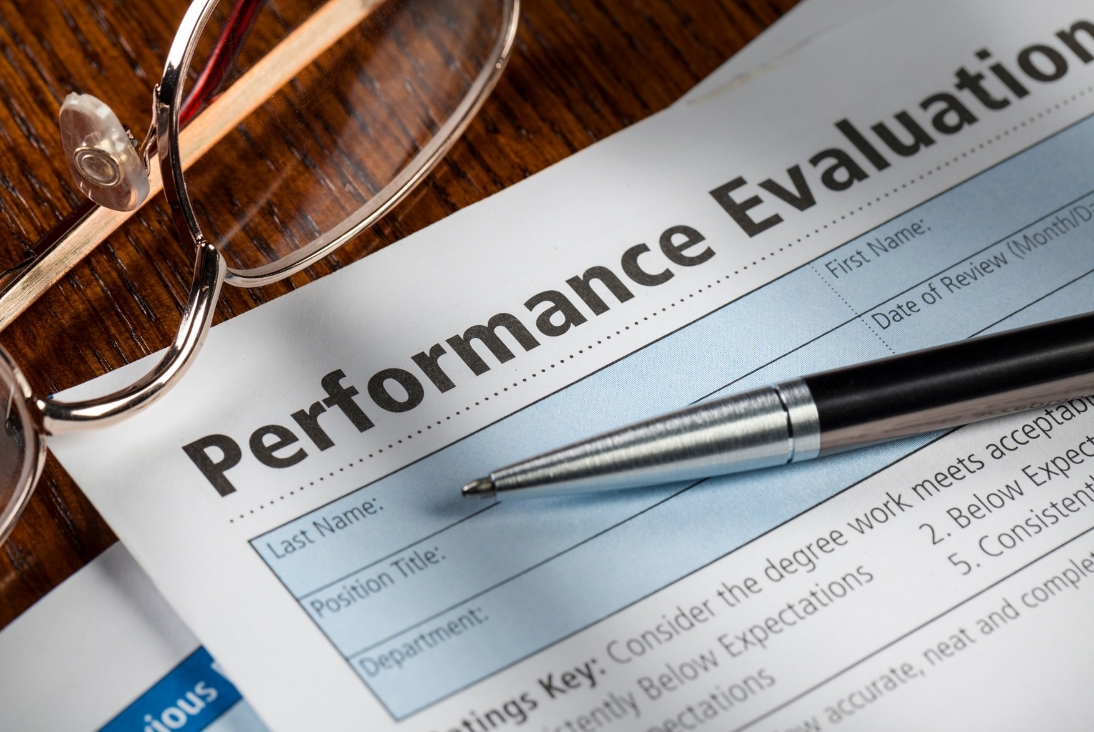 Performance evaluation for CEO succession plan with pen and glasses laying on top